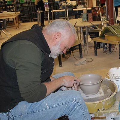 Person throwing a pot at a wheel